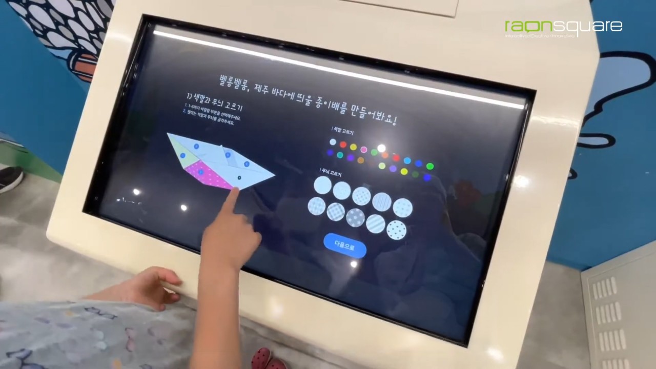 키오스크에서 패턴과 색상을 디자인한 종이배를 출력하고 조립하여 QR코드 인식으로 미디어 월에 등록