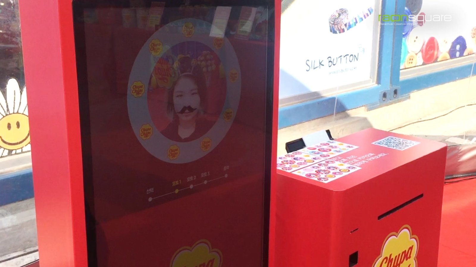 츄파춥스 얼굴인식 AR 포토 스티커는 46인치 키오스크에 키넥트 센서와 프린터를 결합해, AR로 배경과 페이스 스티커를 확인한 뒤 원하는 배경을 골라 스티커로 즉석 출력하는 브랜드 프로모션 사례입니다.